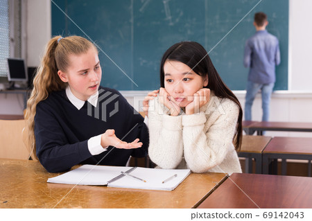 Female classmate calming frustrated Korean teen girl Female classmate calming frustrated Korean teen girl 69142043