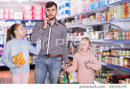 Adult father speaking phone while doing shopping 69142245