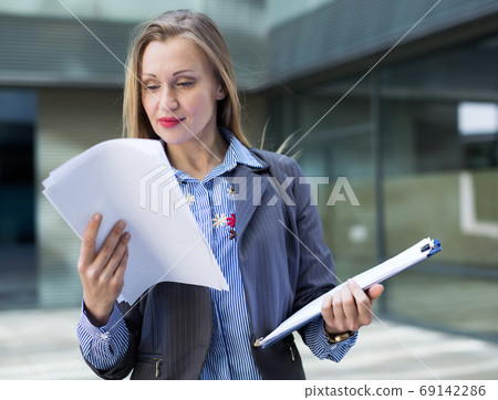 Adult female architect with paper documents Adult female architect with paper documents 69142286