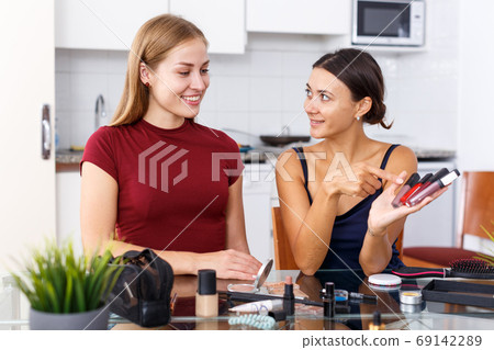 Women friends talking and applying make up Women friends talking and applying make up 69142289