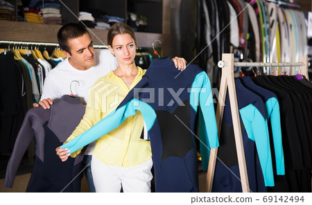 Couple searching wetsuits for surf Couple searching wetsuits for surf 69142494