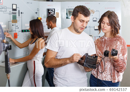 Girl and guy checking telephone set in escape room Girl and guy checking telephone set in escape room 69142537