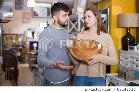 Girl with boyfriend buying original wooden plate Girl with boyfriend buying original wooden plate 69142538