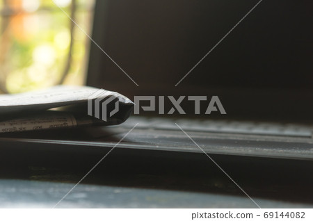 Close Up Newspaper placed on laptop keyboard. 69144082