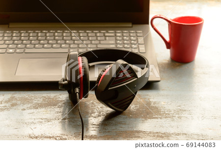 Headphone for Computer, Skype placed near laptop on window sunlight in morning. Headphone for Computer, Skype placed near laptop on window sunlight in morning. 69144083