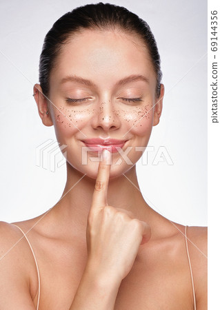 Beautiful young girl with a light natural make-up, glitter freckles and perfect skin. Beauty face. Beautiful young girl with a light natural make-up, glitter freckles and perfect skin. Beauty face. 69144356