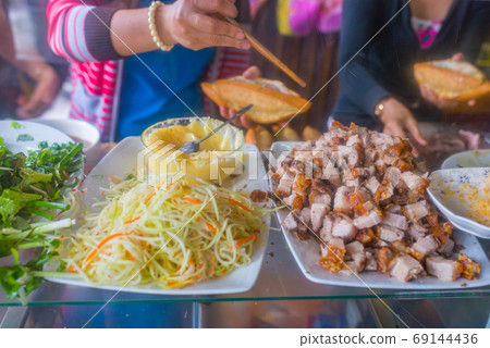 Vietnamese woman making pork sandwich- Banh Mi at hawker vendor 69144436