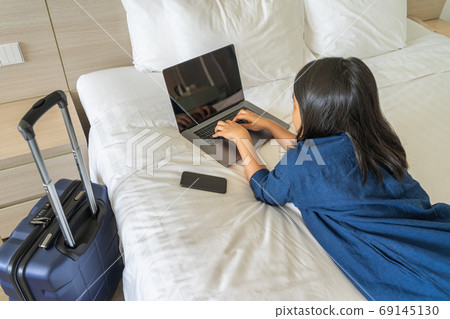 Businesswoman working on laptop in the hotel room Businesswoman working on laptop in the hotel room 69145130