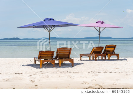 Lounge chairs and umbrella at the white sand beach Lounge chairs and umbrella at the white sand beach 69145165