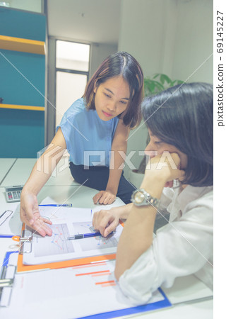 Vertical photo of Asian business people discuss about financial document 69145227