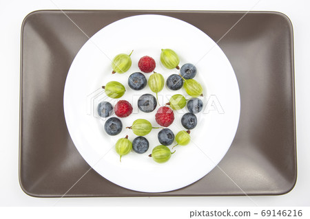 Assorted fresh different berries on a white plate. useful vitami Assorted fresh different berries on a white plate. useful vitami 69146216