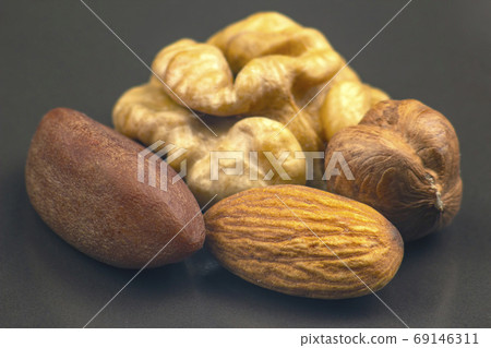 different nuts close-up on a gray background. Healthy food and v different nuts close-up on a gray background. Healthy food and v 69146311