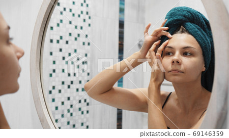 Young woman has problems with skin on the face 69146359