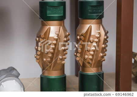 Golden color rock drilling calibrator on shelving in stock. Oil drilling equipment for drilling rig operation on oil platform in oil industry. PDC Polycrystalline Diamond Compact drilling calibrator Golden color rock drilling calibrator on shelving in stock. Oil drilling equipment for drilling rig operation on oil platform in oil industry. PDC Polycrystalline Diamond Compact drilling calibrator 69146962