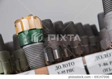 Drill Bits on shelving in stock. Oil equipment for drilling rig operation on oil platform in oil and gas industry. Brand new drilling bits. Written: drill bits 69147006
