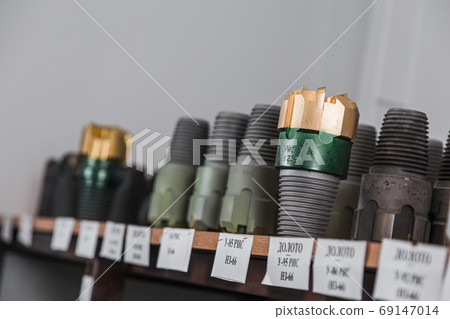 Drill Bits on shelving in stock. Oil equipment for drilling rig operation on oil platform in oil and gas industry. Brand new drilling bits. Written: drill bits 69147014