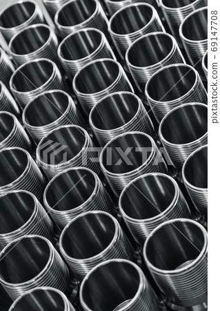 Closeup pattern of shiny circular precision stainless steel industrial machine parts arranged in rows. Steel products to automotive industry. Billet obtained on lathe from steel and cast iron 69147708
