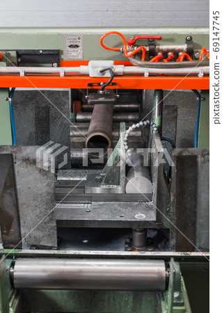 Band saw for industrial high speed cutting metal pipe and using coolant. Raw material for manufacturing process. Precision equipment on manufacture factory line of heavy industry indoors Band saw for industrial high speed cutting metal pipe and using coolant. Raw material for manufacturing process. Precision equipment on manufacture factory line of heavy industry indoors 69147745
