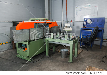 Band saw for industrial high speed cutting metal pipe and using coolant. Hack sawing machine working to cutting metal. Precision equipment on manufacture factory line of heavy industry indoors Band saw for industrial high speed cutting metal pipe and using coolant. Hack sawing machine working to cutting metal. Precision equipment on manufacture factory line of heavy industry indoors 69147748