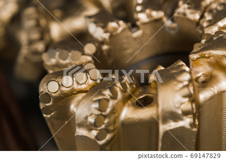 Brand new PDC Polycrystalline Diamond Compact drilling bit. Macro shot of drill bits on shelving in stock. Oil drilling equipment for drilling rig operation on oil platform in oil and gas industry. 69147829