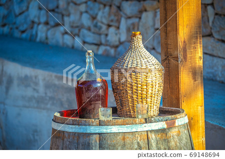 Outdoor still life with red wine in a glass barrel and glasses. Outdoor still life with red wine in a glass barrel and glasses. 69148694