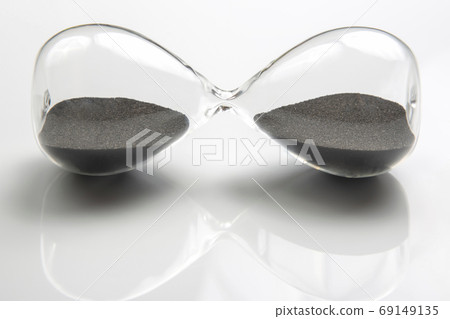 Hourglass on a light background. Time is money. Business solutio Hourglass on a light background. Time is money. Business solutio 69149135