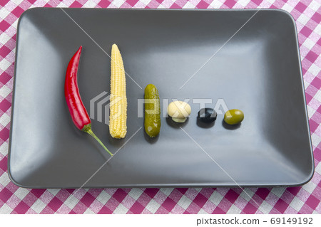 Olives, pickled cucumber, pepper, mushrooms and corn in a salad 69149192