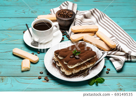 portion of Classic tiramisu dessert, cup of coffee and savoiardi cookies on wooden background portion of Classic tiramisu dessert, cup of coffee and savoiardi cookies on wooden background 69149535