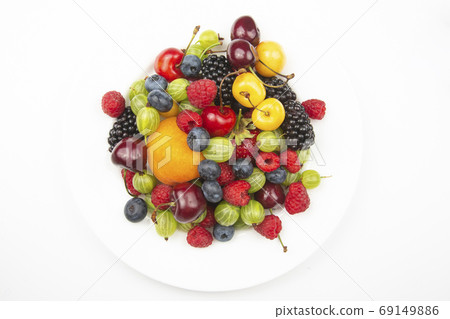 assortment of fresh berries on a white plate. useful vitamin hea 69149886