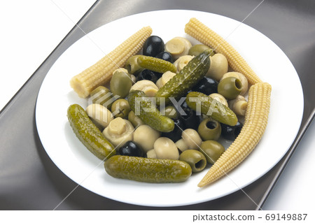 Olives, pickled cucumber, mushrooms and corn in a salad on a pla 69149887
