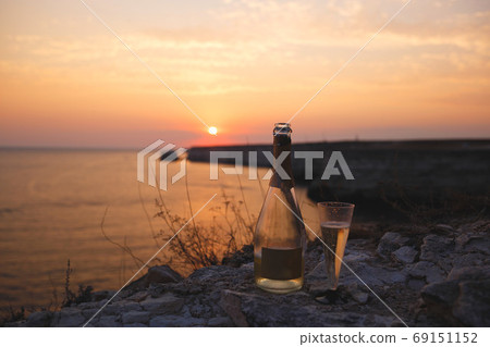 a glass of champagne on the background of the sea and sunset 69151152