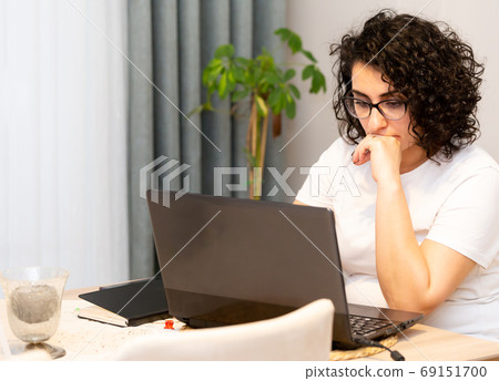 Concentrated young beautiful businesswoman working on laptop at home office. Concentrated young beautiful businesswoman working on laptop at home office. 69151700