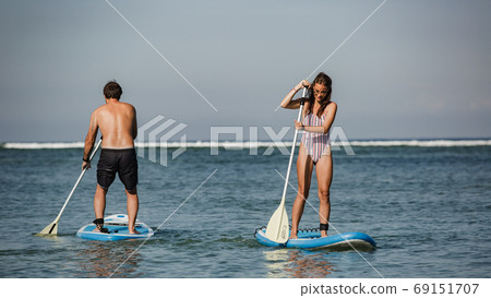 man and woman riding sup 69151707