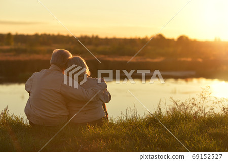 Portrait of senior couple sitting on grass Portrait of senior couple sitting on grass 69152527