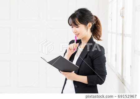 Young business woman with notebook and pen Young business woman with notebook and pen 69152967