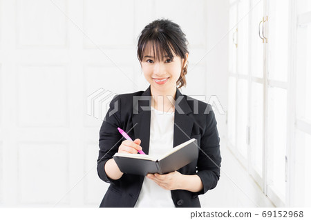 Young business woman with notebook and pen Young business woman with notebook and pen 69152968