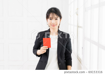 Young business woman holding a red card in her hand Young business woman holding a red card in her hand 69153316