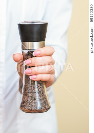 Pepper mills in female hands Pepper mills in female hands 69153380