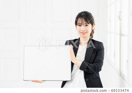 Young business woman with a large sketchbook Young business woman with a large sketchbook 69153474
