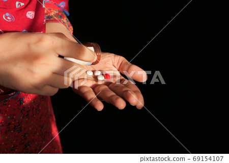 Close up of women hand taking pills Close up of women hand taking pills 69154107