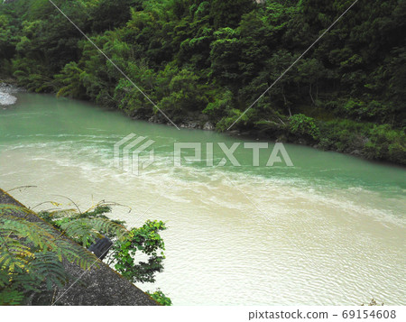 River with dirty water flowing in the mud 69154608