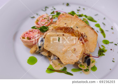 Sliced peanut crusted chicken breast with fresh salad and sauce 69156203