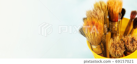 A set of brushes for painting with paints. Many brushes in a yellow metal stand 69157021
