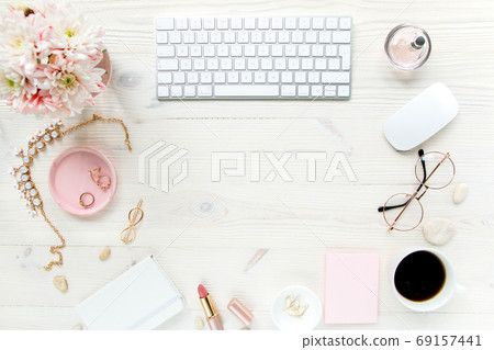 Top view office desk. Workspace with, computer, chrysanthemum, clipboard. Women's fashion accessories isolated on white wooden background. Flat lay Top view office desk. Workspace with, computer, chrysanthemum, clipboard. Women's fashion accessories isolated on white wooden background. Flat lay 69157441