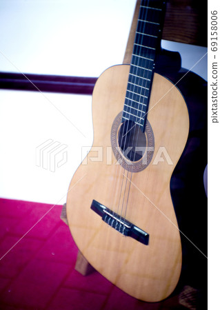Spanish guitar musical instrument perched on a tripod Spanish guitar musical instrument perched on a tripod 69158006