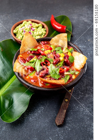 Mexican black bean soup with homemade fried tortillas totopos nachos served with guacamole Mexican black bean soup with homemade fried tortillas totopos nachos served with guacamole 69158180
