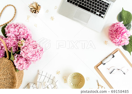 Workspace with clipboard, laptop, bouquet hydrangea, accessories on white background. Stylized women's desk. Flat lay. Top view. Workspace with clipboard, laptop, bouquet hydrangea, accessories on white background. Stylized women's desk. Flat lay. Top view. 69158485