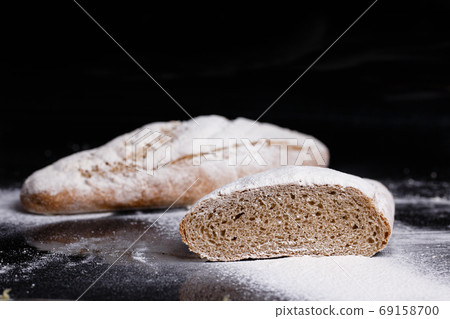 Gray bread sprinkled with flour. Homemade pastries, bread cut gavpil Gray bread sprinkled with flour. Homemade pastries, bread cut gavpil 69158700
