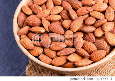 Almonds in a wooden bowl on the table. Almond concept with copy Almonds in a wooden bowl on the table. Almond concept with copy 69163501