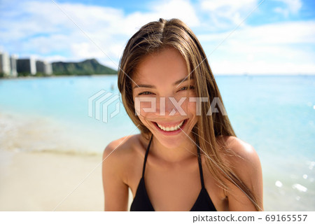 Happy healthy smiling Asian woman - beach vacation Happy healthy smiling Asian woman - beach vacation 69165557